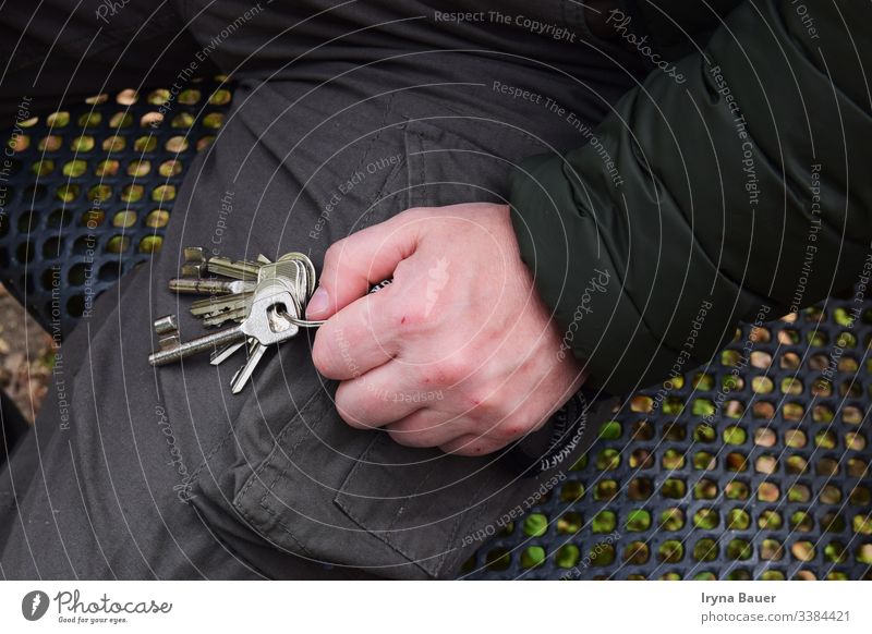 Men with key in the hand. man sits metal bench autumn spring natura outside alone background craft fingers free time human jacket work person lifestyle