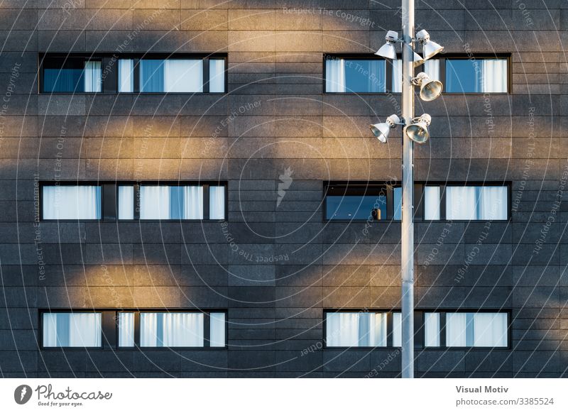 Streetlight and black facade of an urban building windows rows structure Architecture abstract building facade urban facade color exterior repetition no people