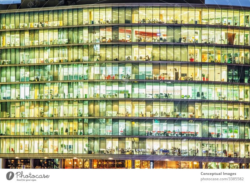 Exterior of an office at dusk, revealing the daily activity of the workers Ambition Architecture Building Building exterior Business Businesspeople Busy