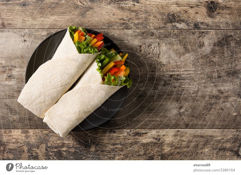 Vegetable tortilla wraps on wooden table. Top view. Copy space burrito carrot cucumber diet fajita food fresh green healthy lettuce mexican mix nutrition pepper