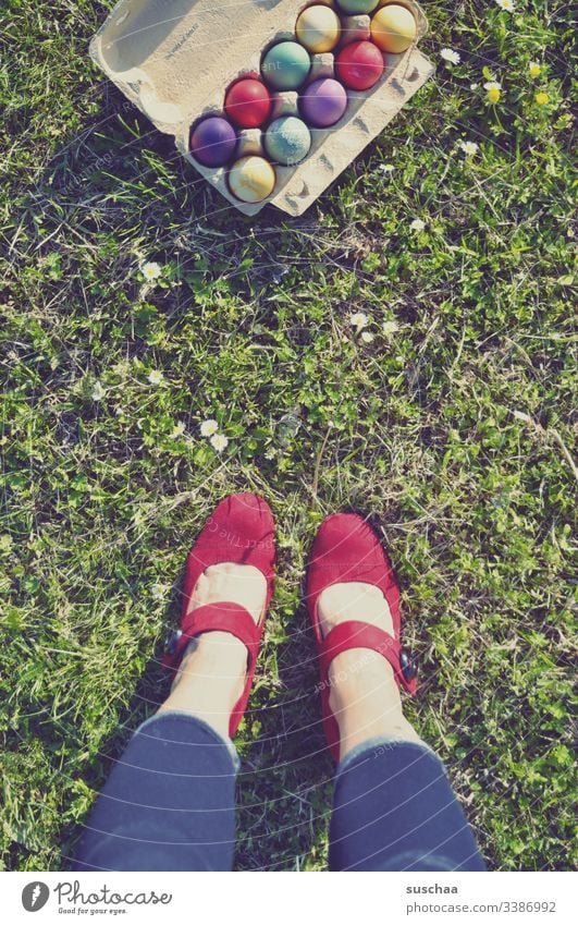 woman standing in front of cardboard box with coloured easter eggs on the lawn Woman feminine Legs feet High heels Lawn Grass Easter Easter eggs colorful eggs