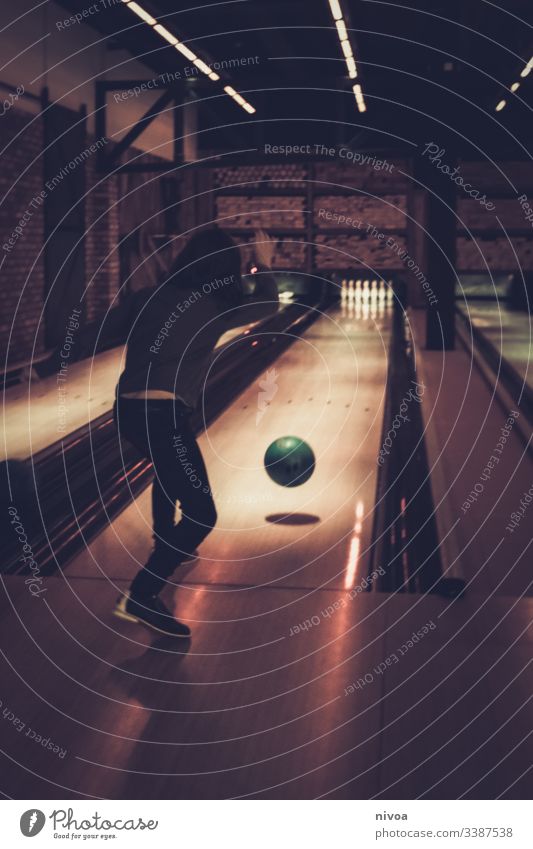 Boy bowling Boy (child) Bowling Bowling alley Bowling ball Light and shadow Indoors Movement Sporting event Joy Nine-pin bowling Playing Sphere