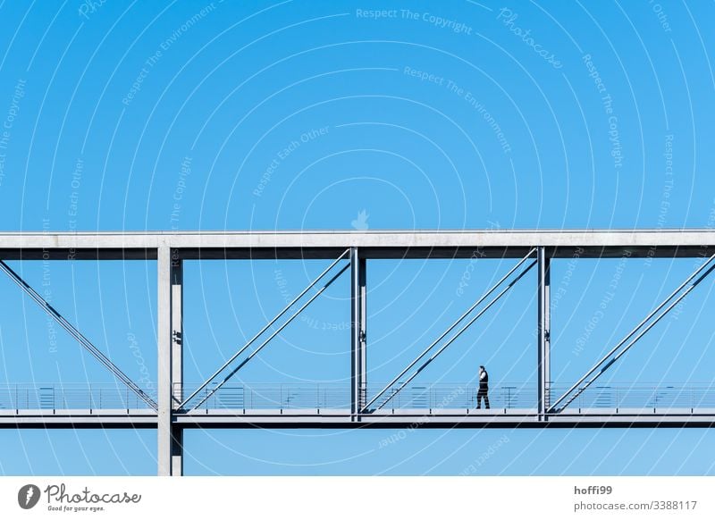 man walk across a minimalistic bridge with deep blue sky Looking away Neutral Background Berlin Esthetic Concrete construction Reichstag Downward Bridge