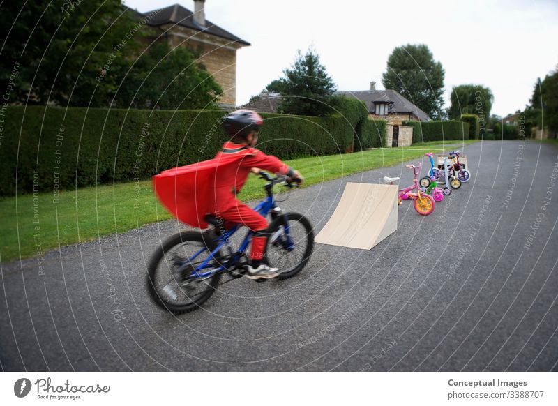 Young boy riding bicycle towards ramp action adrenaline adventure bicycling bike biker biking blurred blurred motion bmx child childhood concept danger