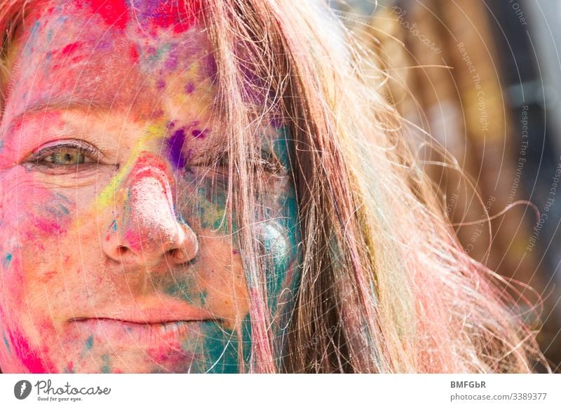 happy woman portrait with colors from holy festival in her face excited crazy enjoying festival of colours tourism concept happiness summer fun travel india