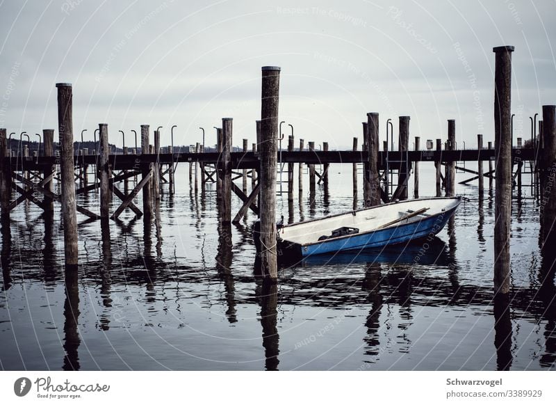 Boat on the quay boat wharf Footbridge Lake Lake Constance Reichenau invested Water Watercraft created Pole reflection Reflection in the water Blue Calm