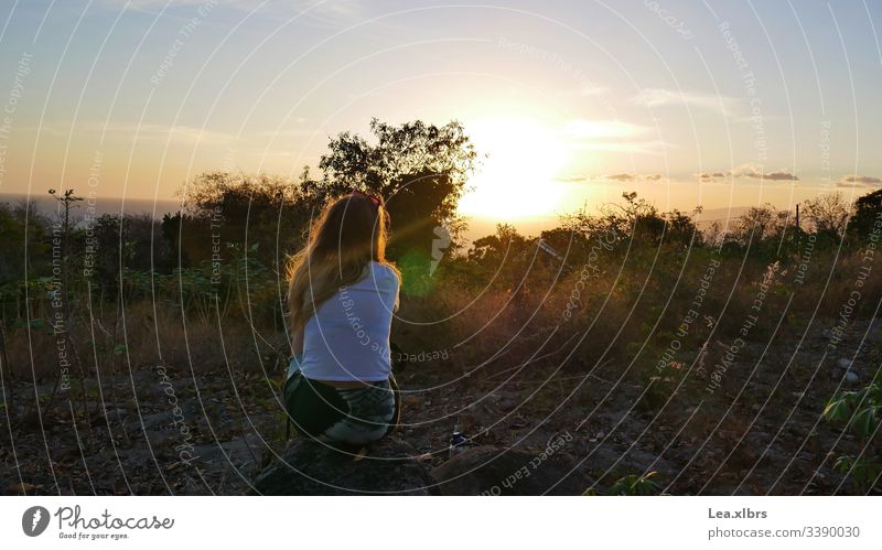 A woman is sitting on a stone, looking at the sunset. All around you is nature. Wanderlust Sunset relax hopeful new Nature Island romantic Lonely Wind To enjoy