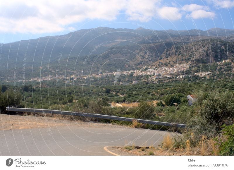 Cretan mountain road with view of Kritsa Crete Greece Island Mountain village Street Asphalt Crash barrier abyss plants Green mountainous Village white houses