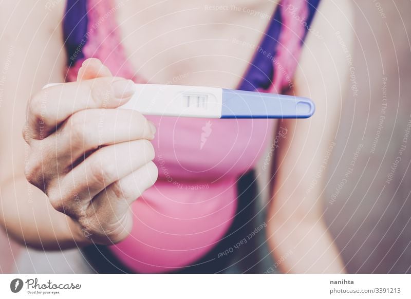 Woman holding a positive pregnancy test pregnant mom mother woman family happiness happy pink close up belly month week third proof love lovely mid section body