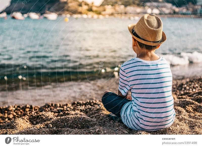 Little kid with hat looking the sea on the beach back background beautiful blue child childhood children coast contemplation cute enjoying fashion fashionable