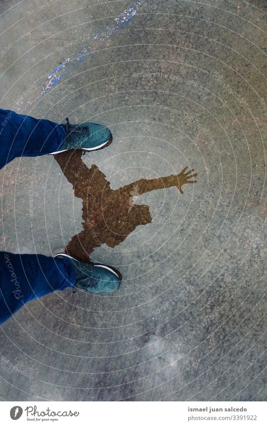 man reflected on the puddle on the ground, rainy days person human pedestrian water reflection shadow silhouette outdoor background floor