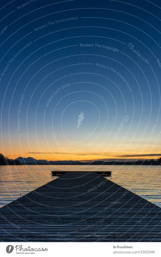 Evening light at the lake Sunset Footbridge wooden walkway Lake Water Sky Twilight evening light Calm Lakeside Deserted Landscape mountain Beautiful weather