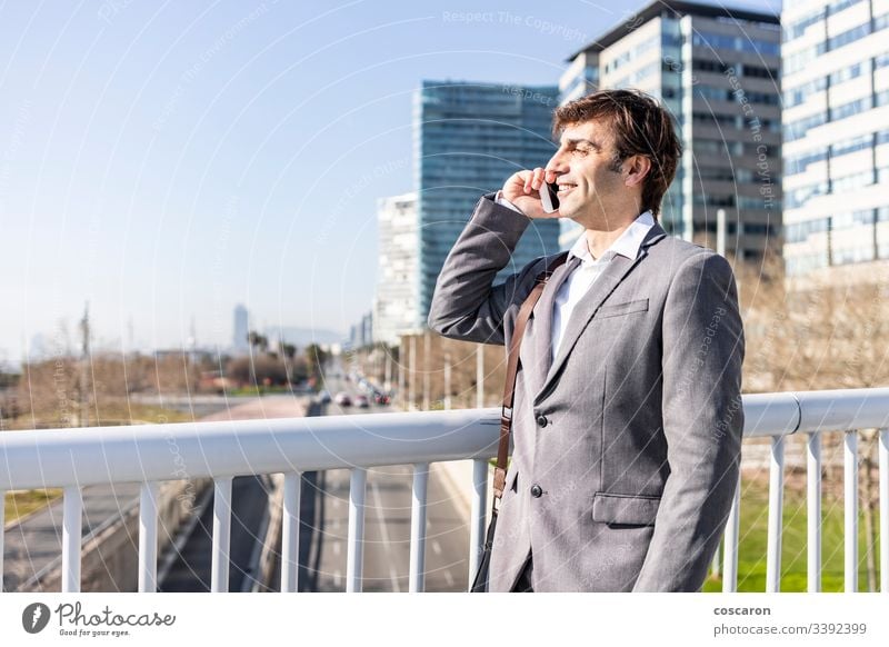 Happy businessman using a cellphone on the city adult barcelona bridge buildings call cityscape copyspace elegant enjoy fun handsome happy job laughing