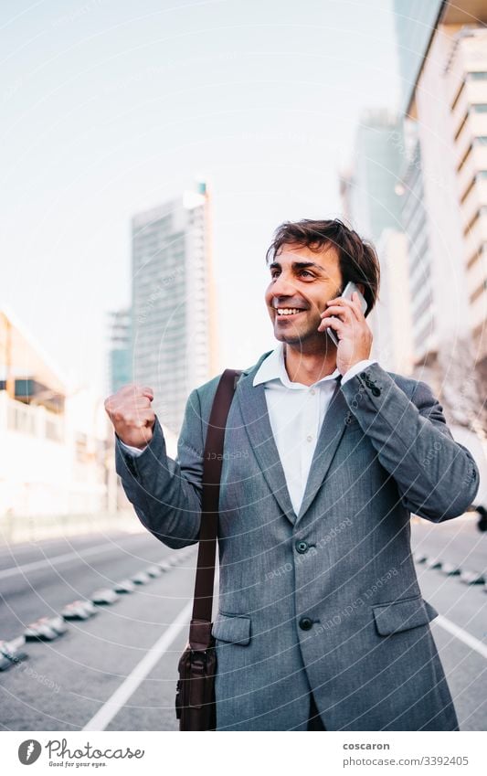 Handsome mature businessman celebrating victory achievement barcelona beard building businessperson cellphone cellular cheerful city communication concept