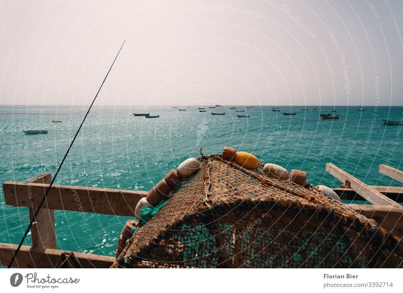 Fishing place with fishing baskets and view of the sea with small boats Fishing village Angler Footbridge Offer Merit Income Water Survive food chain