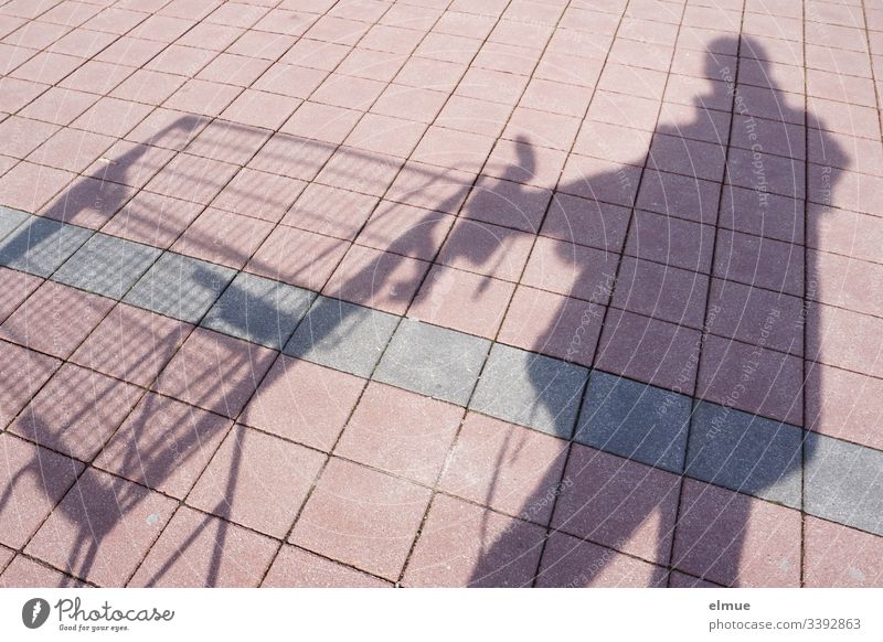 Shadow person with shopping cart Shadow play Shopping Trolley Sunlight Day Deserted Colour photo Parking lot tiles Square Perspective plan surface fun Funny