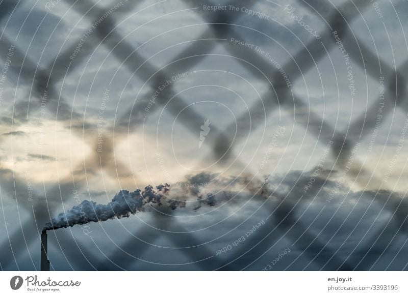 Smoking chimney behind blurred fence Fence Chimney Smoke smoke Sky Clouds Industry Climate Climate change Environment Environmental protection