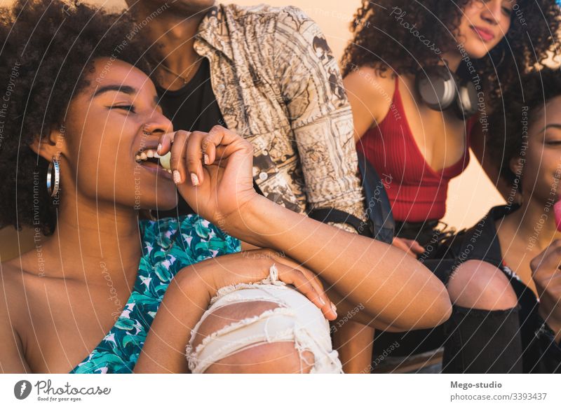 Multi-ethnic group of friends enjoying summertime while eating ice cream. multiethnic friendship young people dessert diversity diverse pleasure man woman