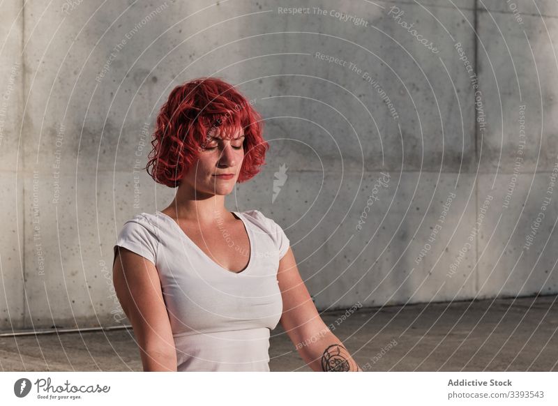 Woman with eyes closed meditating in lotus pose on street during sunset woman meditate yoga tranquil practice gyan mudra flexible idyllic gymnastic athlete