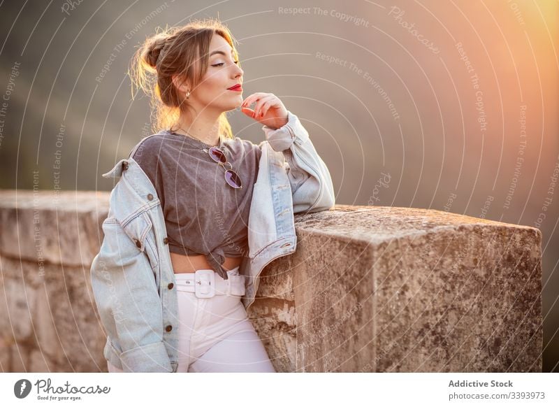 Stylish woman in casual wear delighting in view smile enjoy sun style trendy lifestyle harmony fashion rest relax outfit weekend contemporary young idyllic calm