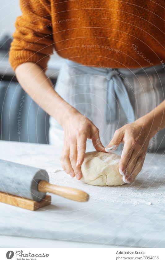 Cook kneading dough with hand on table cook rolling pin flour preparation bakery kitchen culinary making apron recipe food homemade prepare raw cuisine