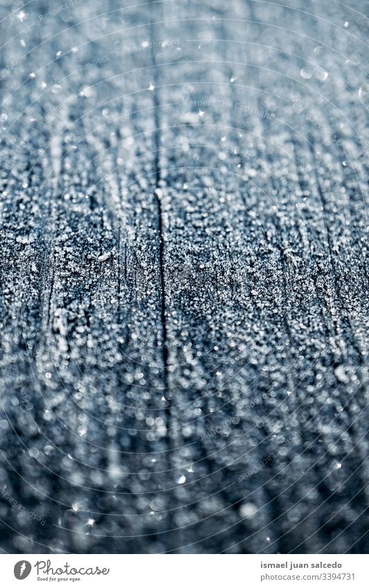 snow and ice on the wooden table in winter season, abstract background frost frosty frozen water drops cold white bright shiny wintertime snowfall wet textured