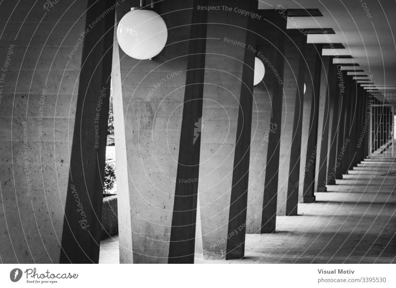 Outdoor hallway with columns in black and white grayscale photography greyscale contrast lamps outdoor exterior structure perspective abstract repetition