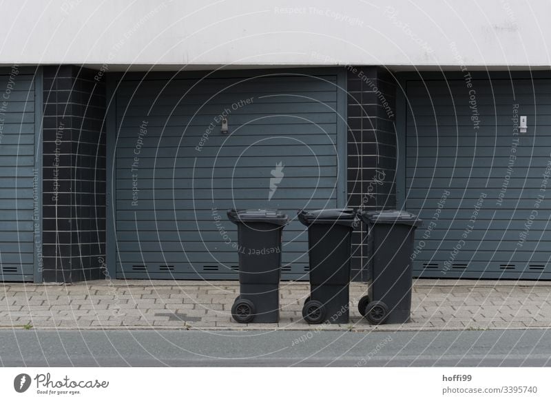 three dustbins at the roadside Residual waste residual waste bin Refuse disposal Facade Garage door garage entrance Exterior shot Building