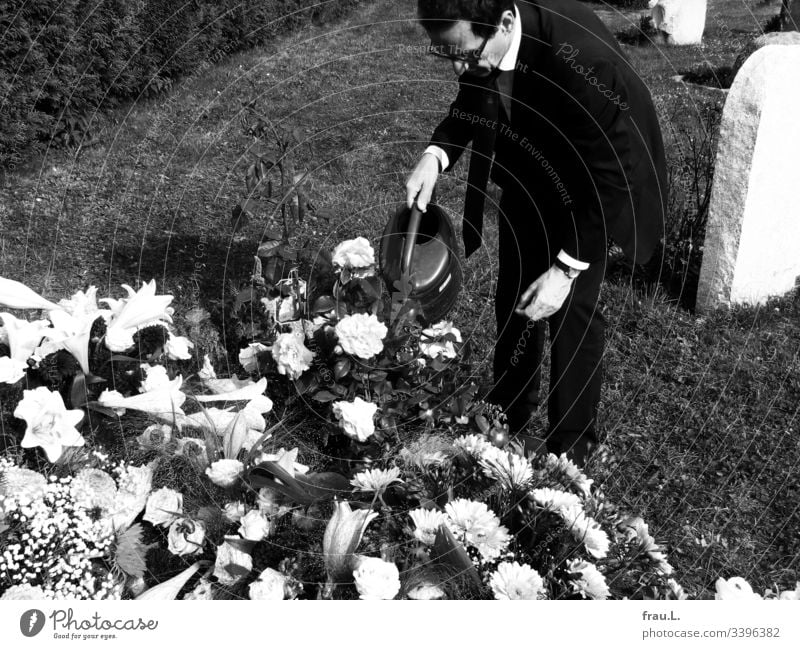 Something could still be done for the old man, he thought, and watered the flowers on the fresh grave. Grave Cemetery Grief Funeral Exterior shot Death Sadness