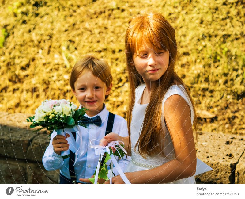 Ring bearer and flower girl at summer wedding ring bearer junior bridesmaid children fashion floral rose kid nature face sun dress happy portrait bouquet