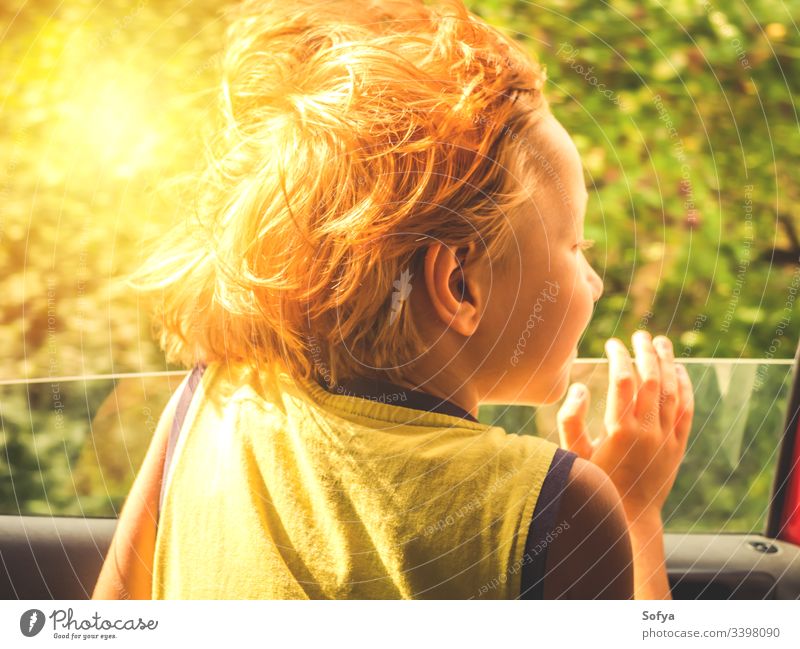 Little boy enjoying sun and wind travelling in a car little child happy skin emotion moment hair summer sunny day light t-shirt yellow blonde caucasian eyes kid