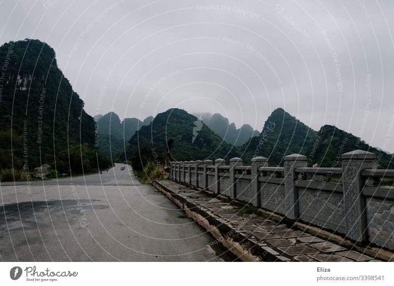 A stone bridge in front of a beautiful mountain landscape with limestone rocks in Ninh Binh, Vietnam Landscape Bridge mountains Street travel Vacation & Travel