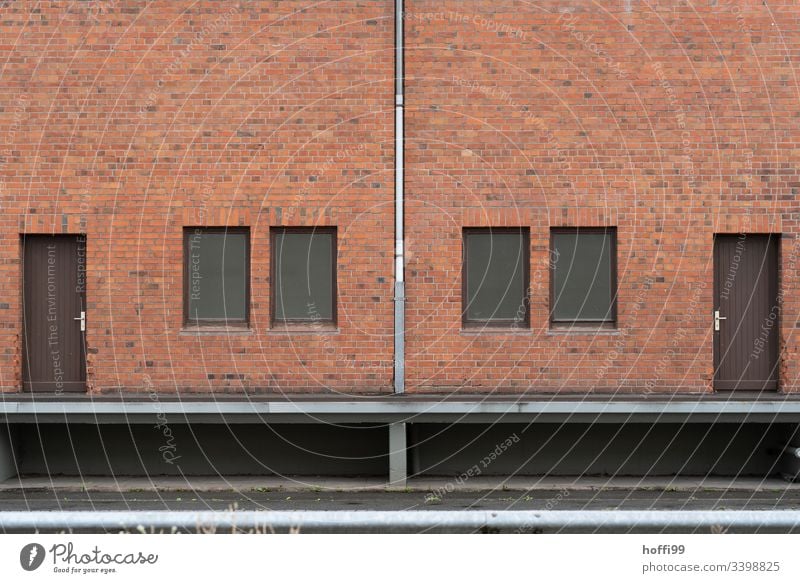 Symmetrical red brick facade with downpipe, doors and windows clinker facade brick wall Downspout Door Symmetry Window Venetian blinds Closed Warehouse Depot