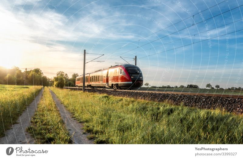 Passenger train on sunny day of summer in Germany German train Railroad blue sky eco-friendly electric vehicle europe european golden hour green fields