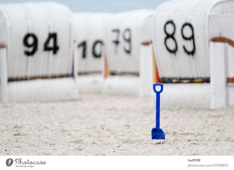 blue shovel in focus in front of blurred white beach chairs on the beach Beach chair Blue Shovel Kids shovel vacation Relaxation Coast Ocean Sand Baltic beach