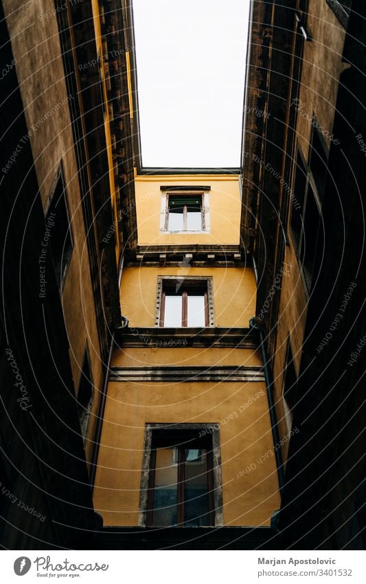 Low angle view of a narrow alley in Venice, Italy alleyway ancient architecture background building city cityscape contrast day design europe european exterior