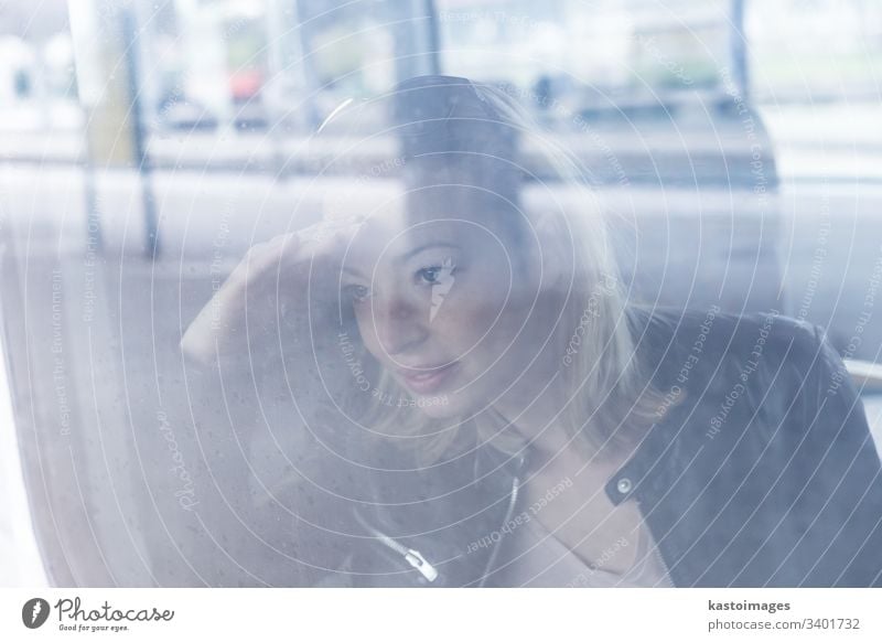 Young woman traveling by train, looking out window while sitting in train. girl young female passenger ride railway adult journey person transport