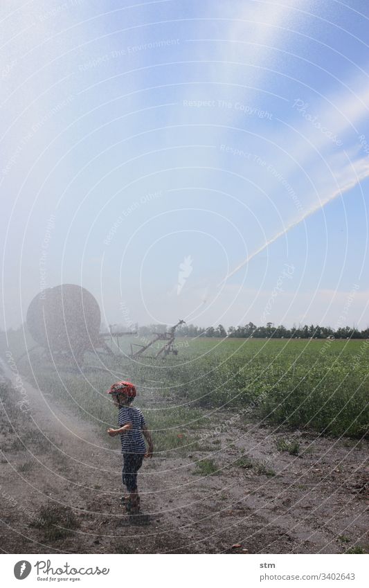 child dancing in the rain Rain Water Lawn sprinkler Summer Wet Drops of water Cast Exterior shot Child fun Joy Infancy Playing Happiness Inject Boy (child)