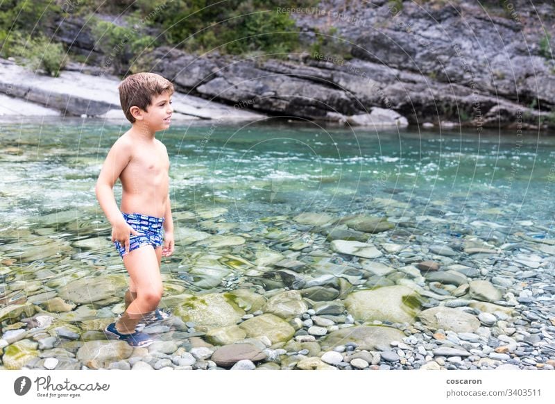 Little child in the middle of a wild river activity alone cheerful childhood cinca coast crossing day enjoyment flow fun game girl happiness healthy holidays