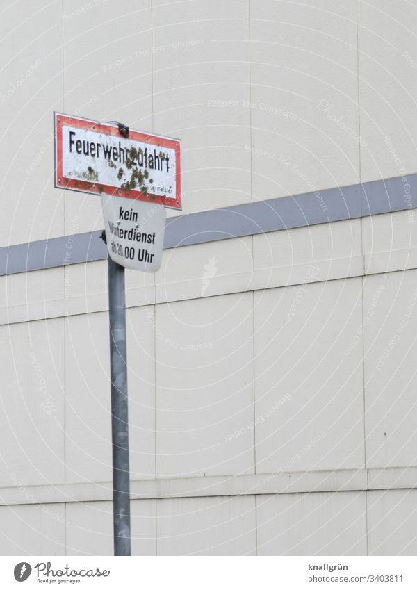 Dirty fire department access sign and winter service sign in front of a public building communication Signs and labeling Signage Road sign Warning sign