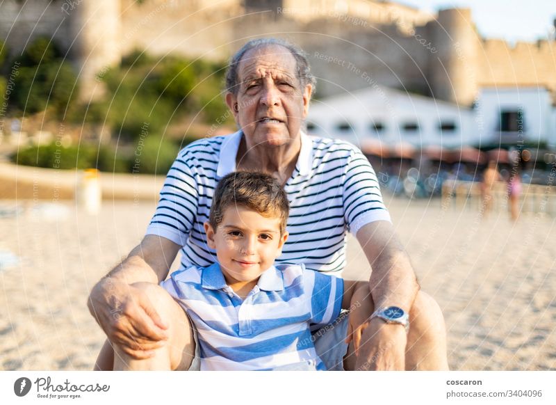 Portrait of grangfather and grandson on the beach boy caucasian cheerful child children coast enjoyment family fun girl grandchild grandchildren granddaughter