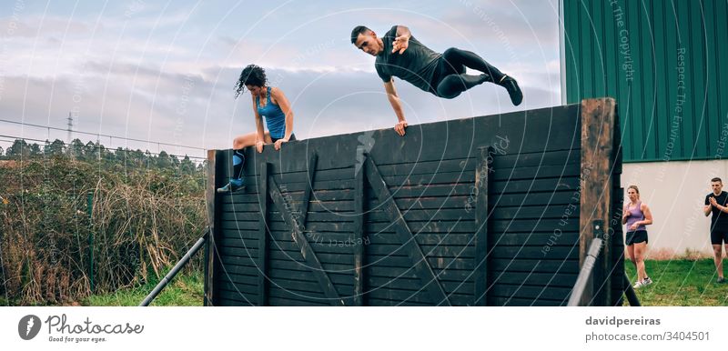 Participants in obstacle course climbing wall obstacle course race man jumping overcoming ocr banner web panorama panoramic fly runner exercise women outdoors