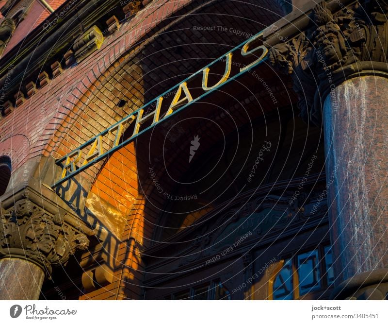 The town hall in the shadow of the evening sun Typography Shadow play columns Round arch Worm's-eye view Architecture Facade Entrance clinker facade