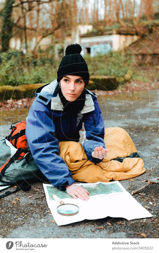 Hiker navigating with map and compass in countryside hiker navigate traveler check topographic map magnifying glass ground equipment cartography tool