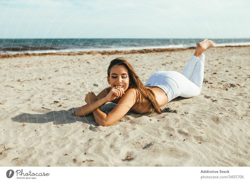 Cheerful young topless woman on beach sensitive lie sandy sunlight summer feminine female temptation seductive natural model charming romantic tender