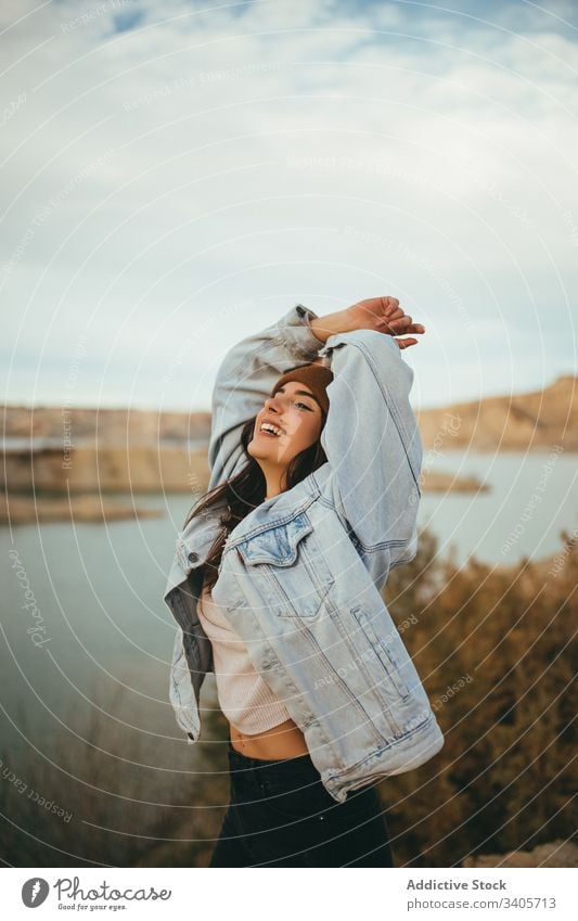 Cheerful young woman in countryside in autumn tourist enjoy weekend journey lake nature female vacation travel freedom romantic carefree destination rural