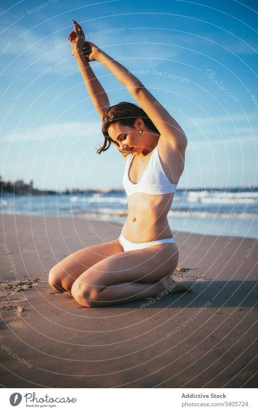 Happy young woman enjoying summer on beach tourist knee sunlight sandy vacation female sea relax holiday coastline freedom carefree shore nature resort romantic