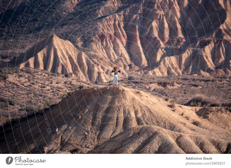 Unrecognizable female on dry sandy hill woman nature admire adventure stone landscape travel bardenas reales navarre spain desert journey explore mountain