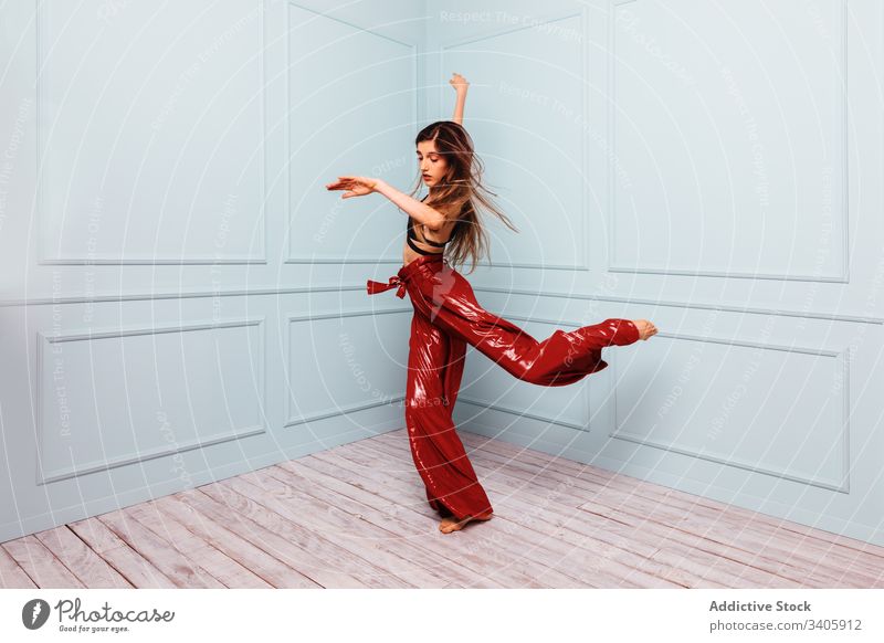 Stylish dancer jumping in corner of studio woman style shaking hair modern slim elegant model female trendy outfit fashion glamour vogue move barefoot energy