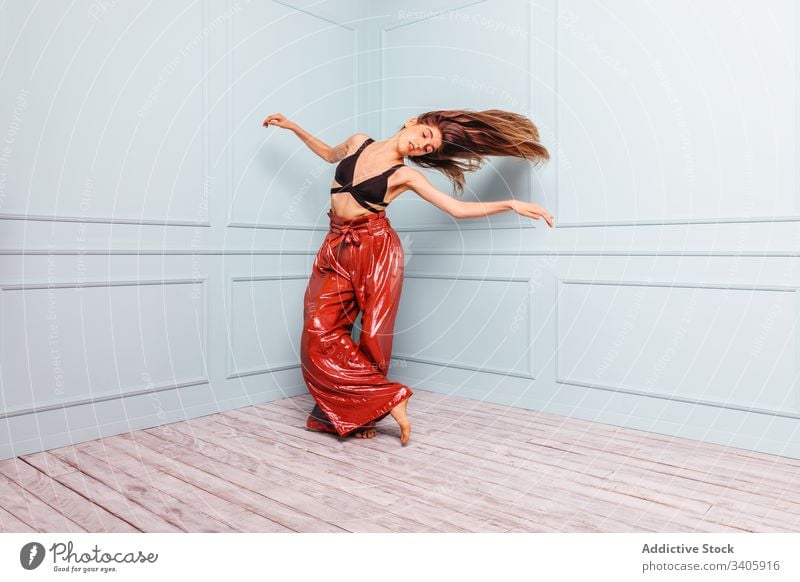 Stylish dancer dancing in corner of studio woman jump style shaking hair modern slim elegant model female trendy outfit fashion glamour vogue move barefoot